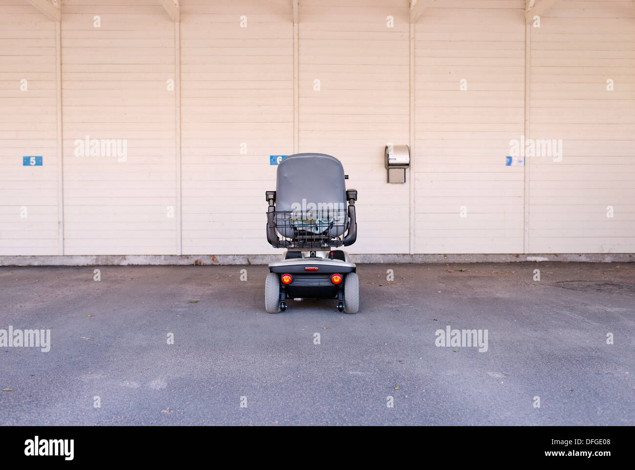 Ein Elektro-Rollstuhl allein in einer Garage. Konzeptbild des Erhaltens, alte, Behinderte und einsam Stockfoto
