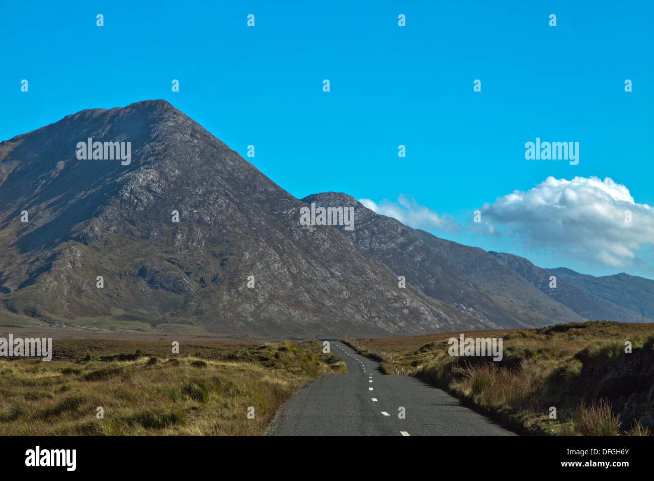 Eine landschaftlich reizvolle Fahrt im Inagh Valley, mit robusten Bergblick, Grafschaft Connemara, County Galway, Irland. Stockfoto