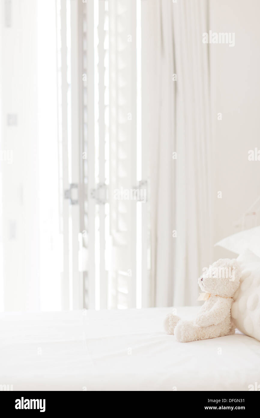 Teddybär auf weißen Bett Stockfoto