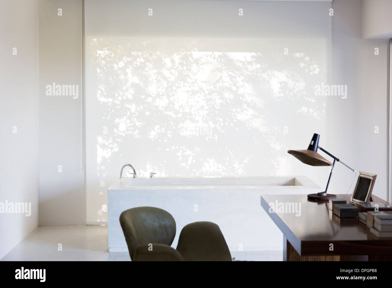 Schreibtisch und Badewanne im modernen Haus Stockfoto