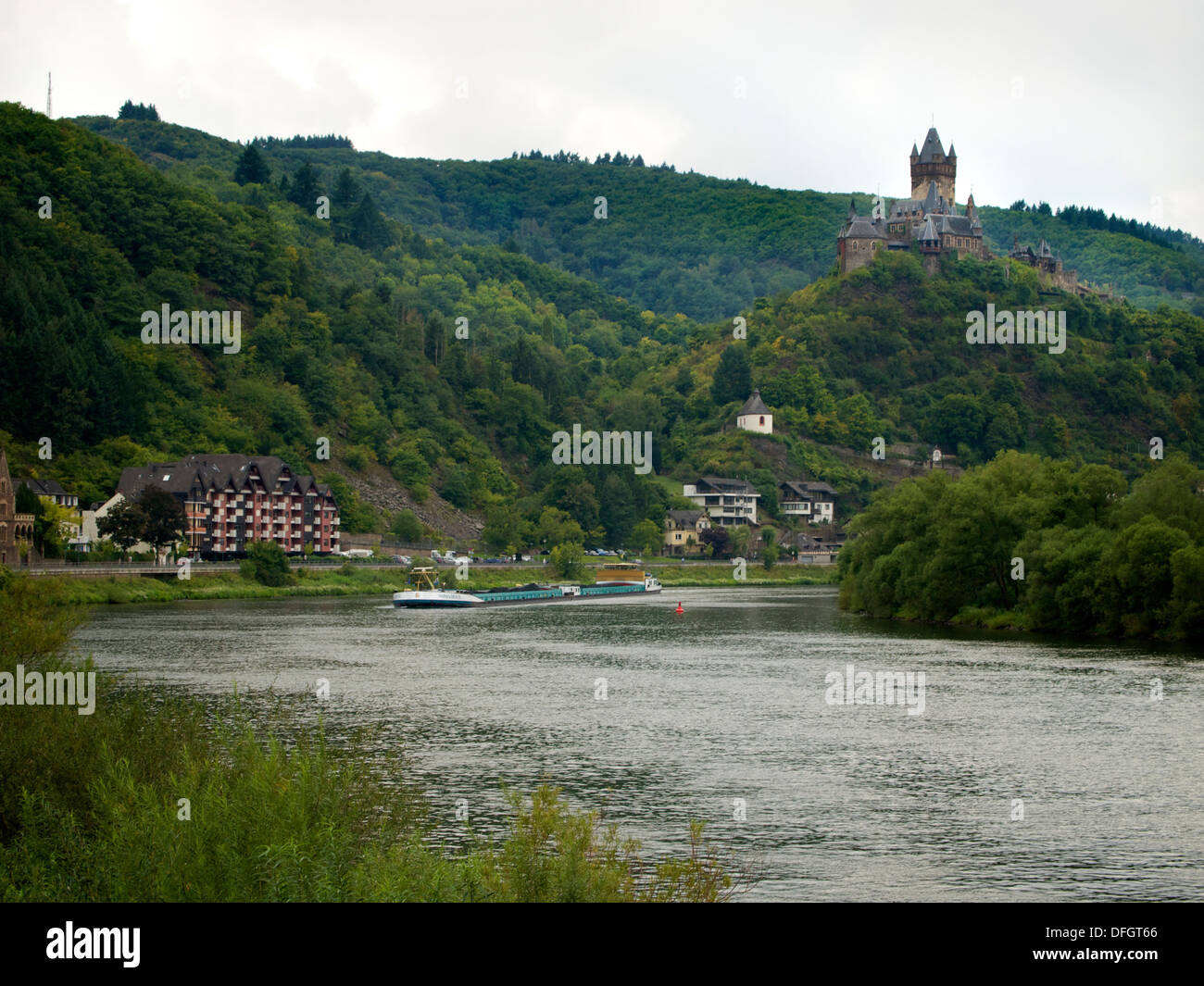 Die Mosel bei Cochem mit der berühmten Burg Cochem und einem vorbeifahrenden Fracht versenden. Deutschland Stockfoto