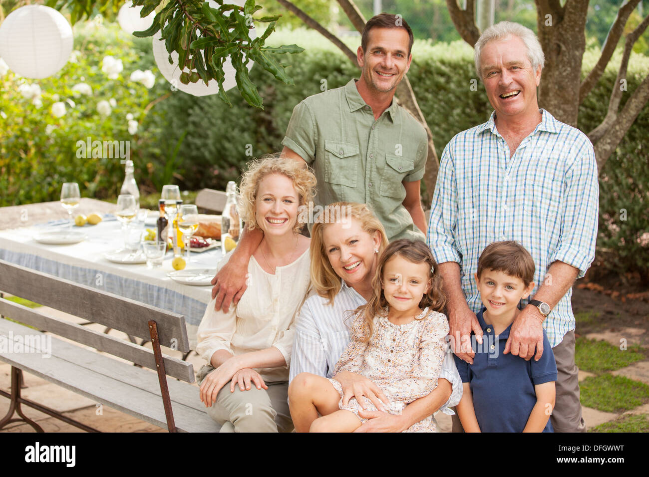 Porträt von Lächeln mehr-Generationen-Familie am Tisch im Garten Stockfoto