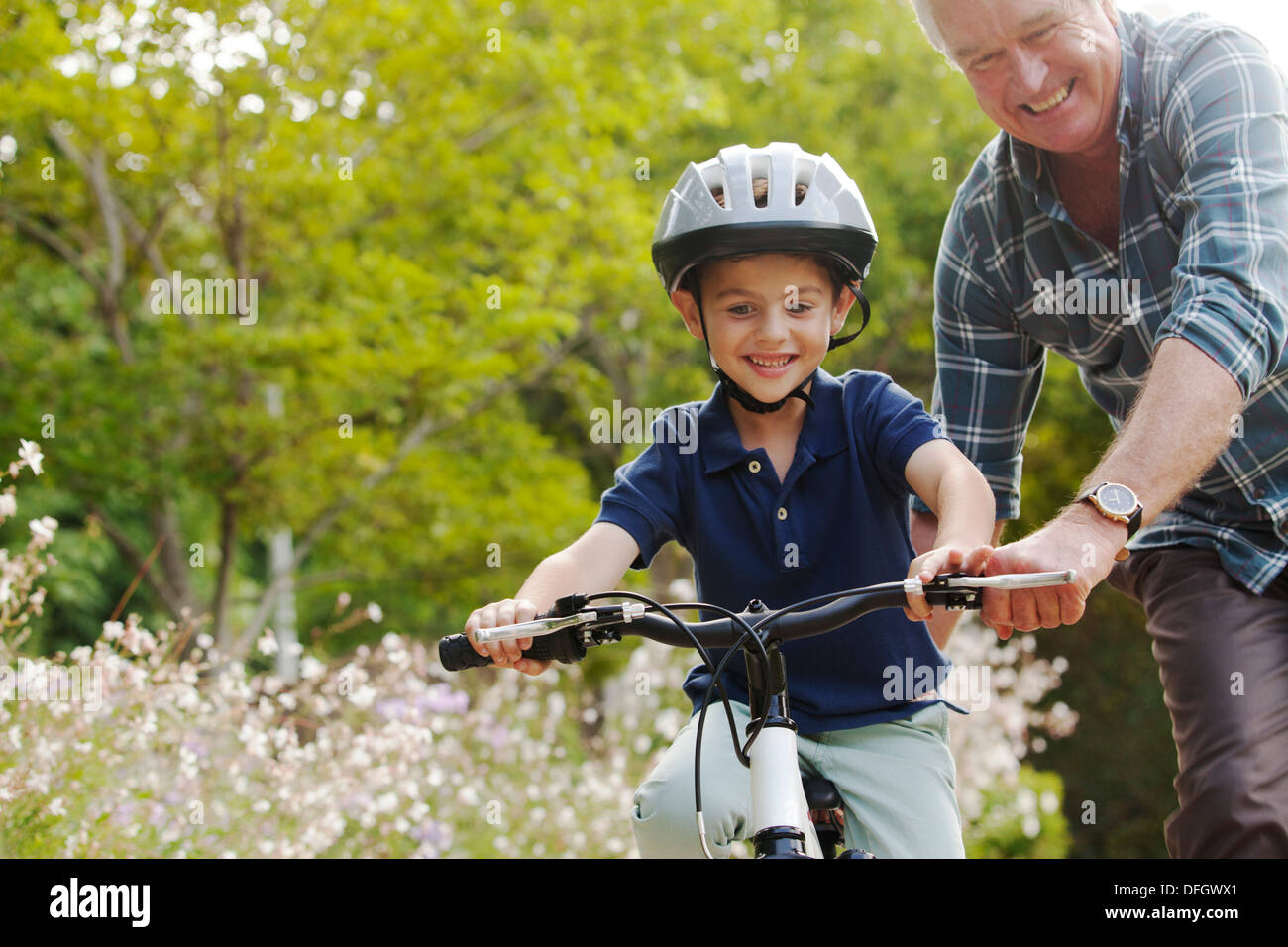 Großvater lehrt Enkel, Fahrrad fahren Stockfoto