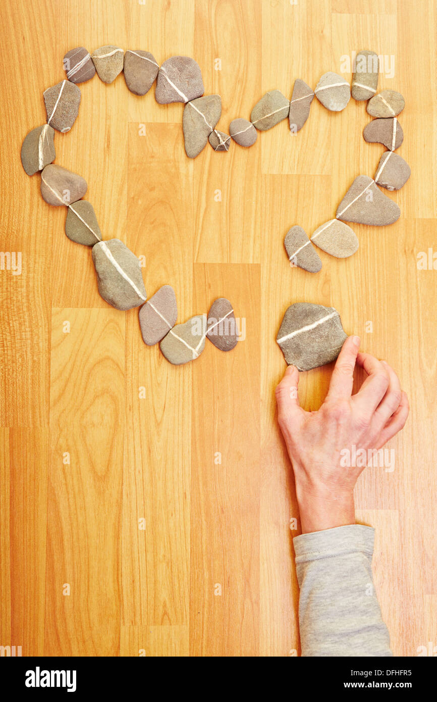 Hand setzen Stein Steine in Liebe Herzform Stockfoto