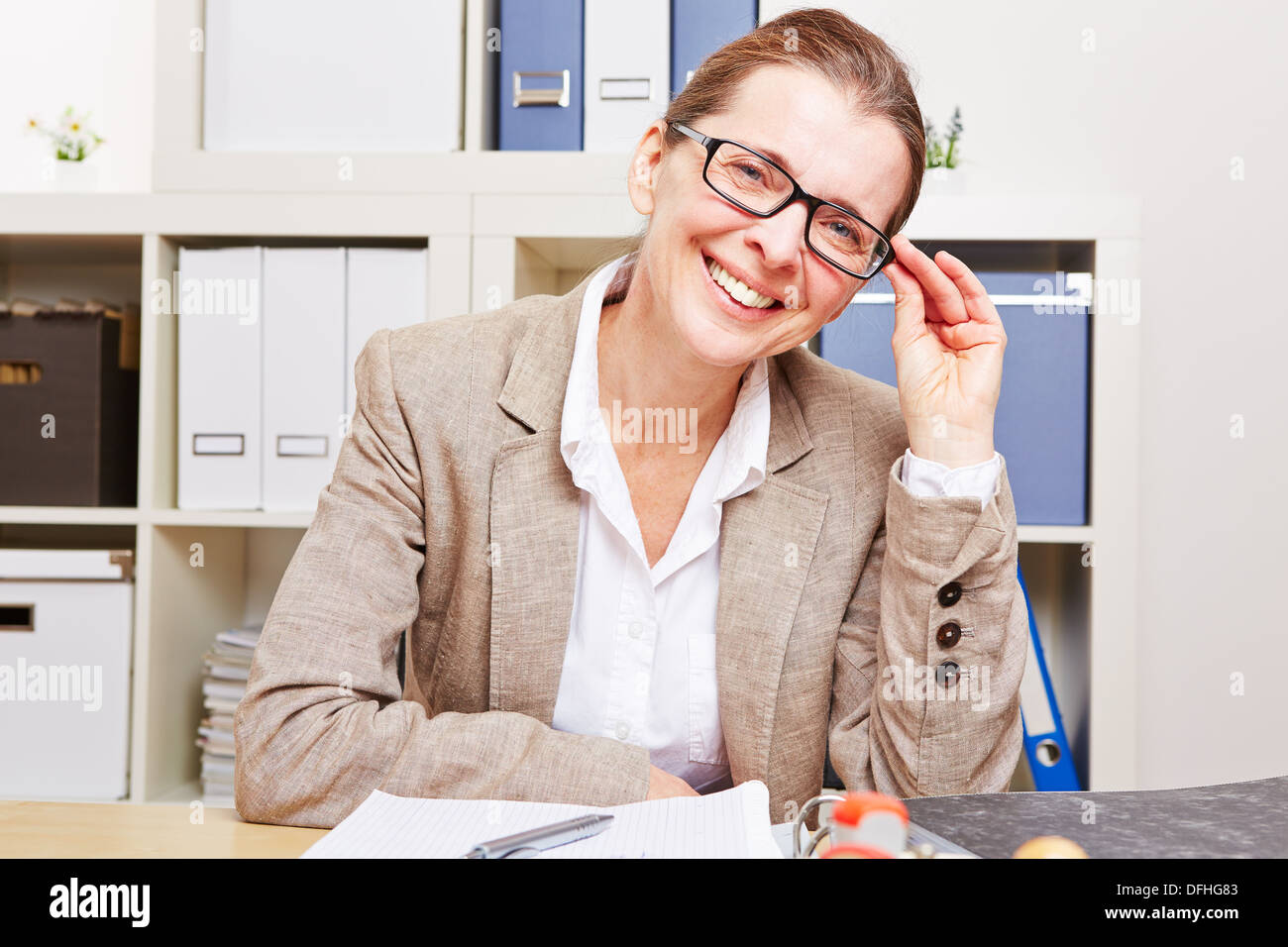 Kurzsichtig Business-Frau mit Brille sitzt an ihrem Schreibtisch im Büro Stockfoto