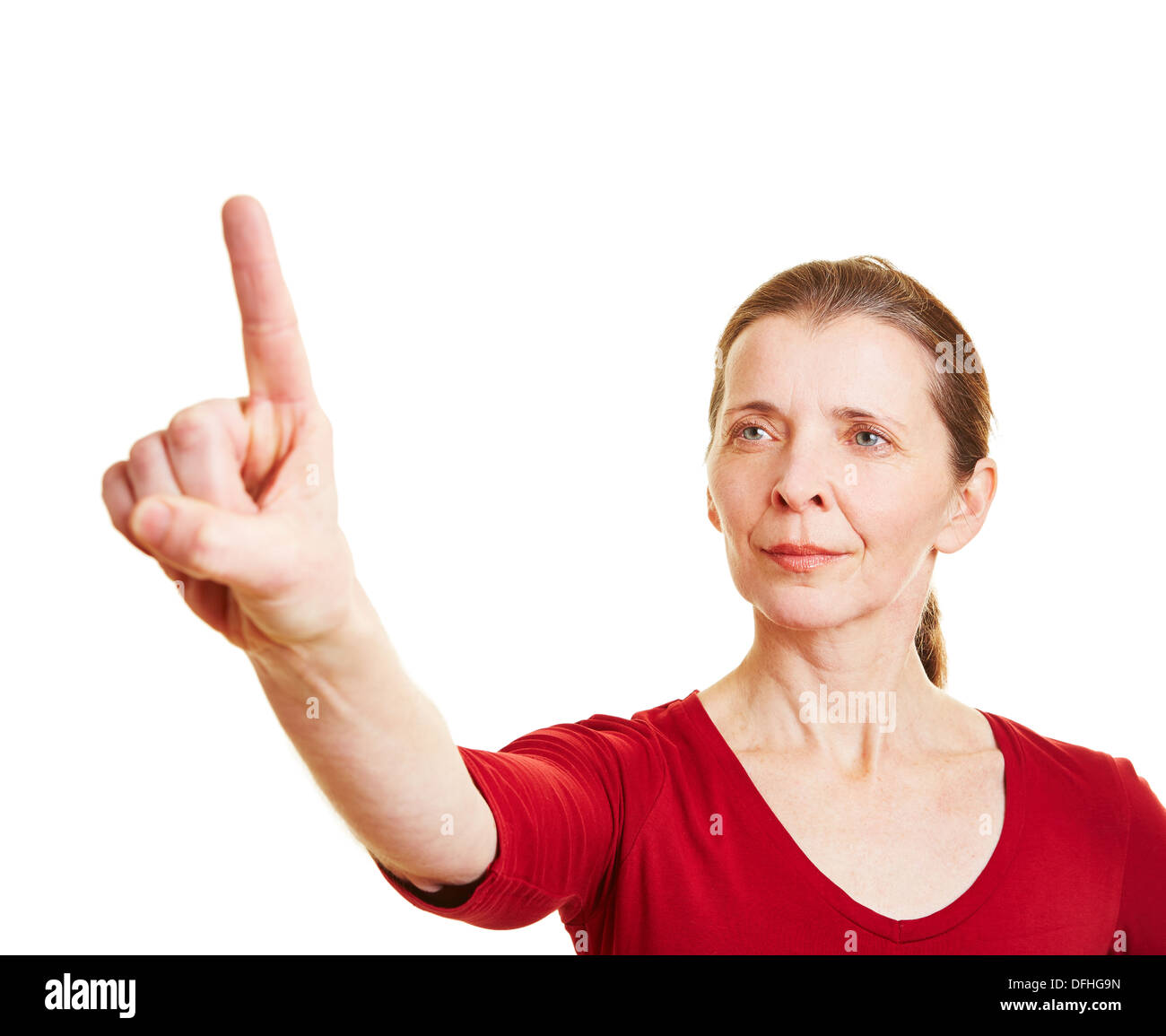 Ältere Frau Zeigefinger hochhalten und unsichtbare Touchscreen drücken Stockfoto