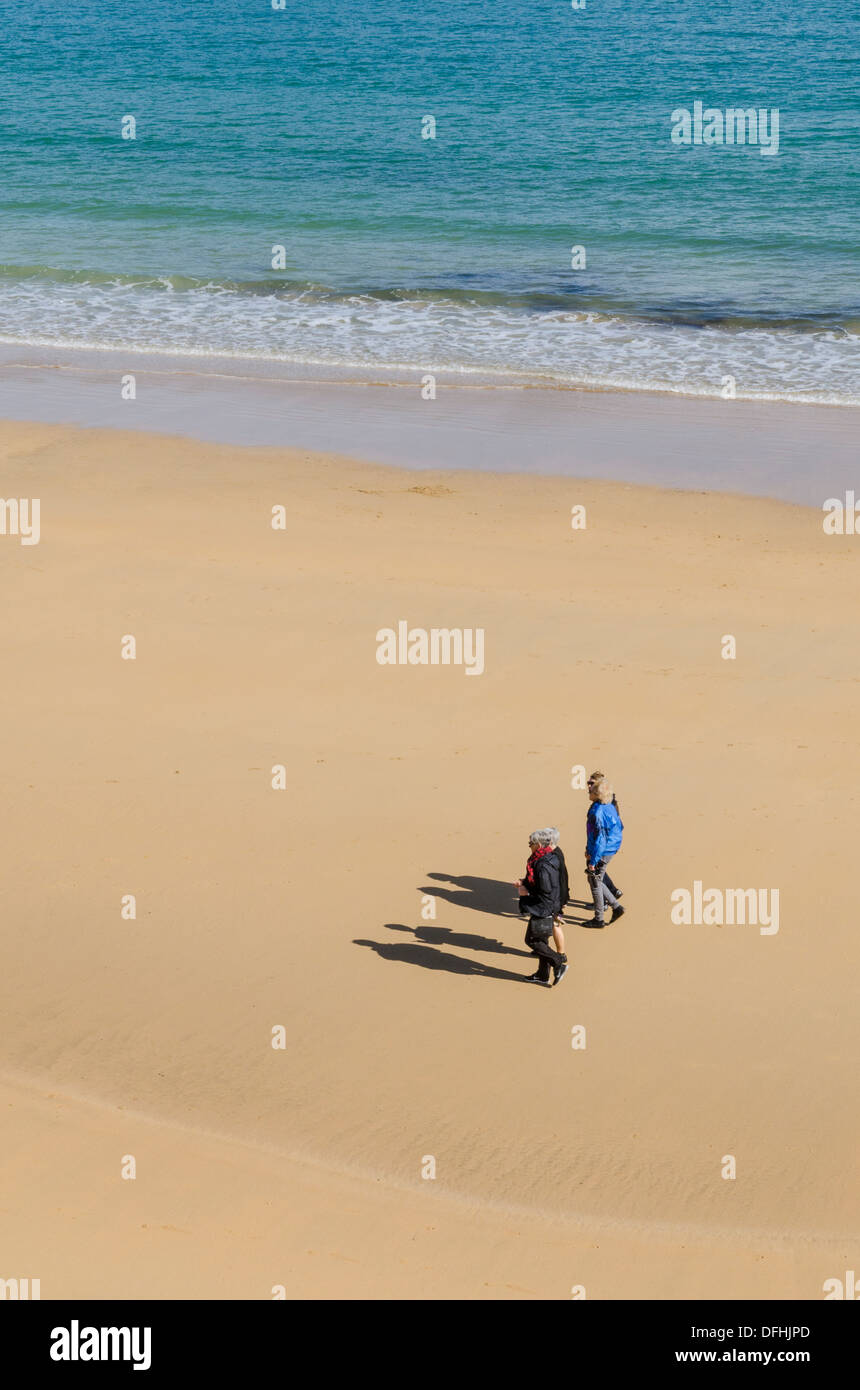 Vier Frauen, die einen Strand entlang spazieren Stockfoto