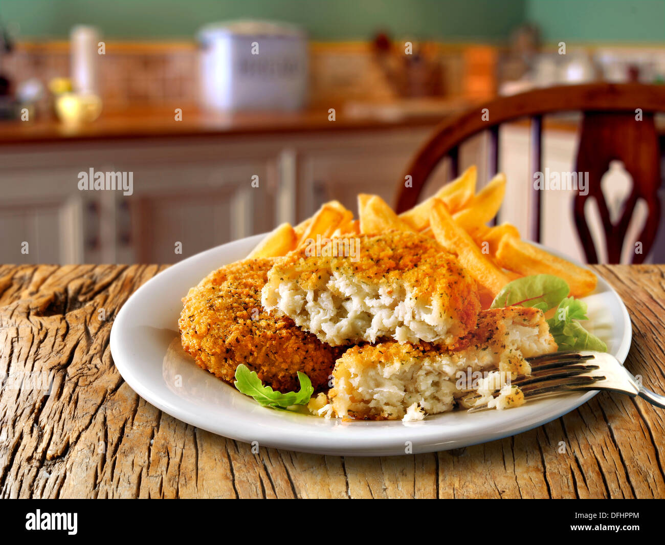 Britische Lebensmittel - panierte Fisch Kuchen & Chips Stockfoto