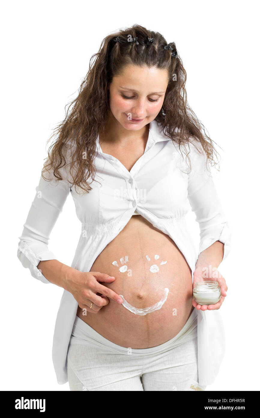 Schwangere Frau Auftragen der Creme auf dem Bauch Stockfoto