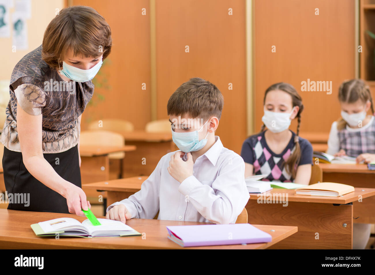 Schülerinnen und Schüler und Lehrer mit Maske Schutz gegen Grippe-Virus bei Lektion Stockfoto