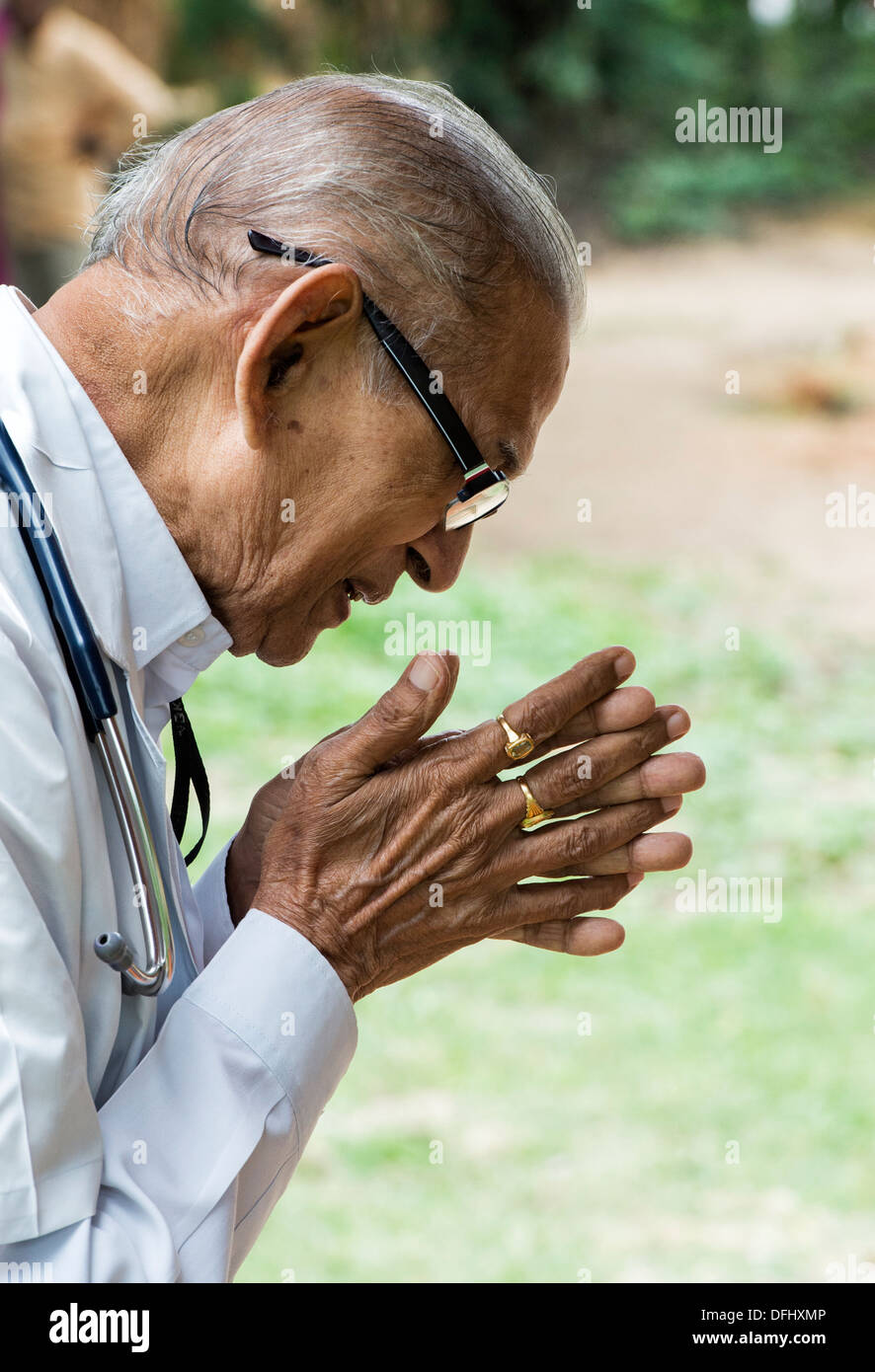 Indischer Arzt im Gebet am Sri Sathya Sai Baba mobile aufsuchende Hospital. Andhra Pradesh, Indien Stockfoto