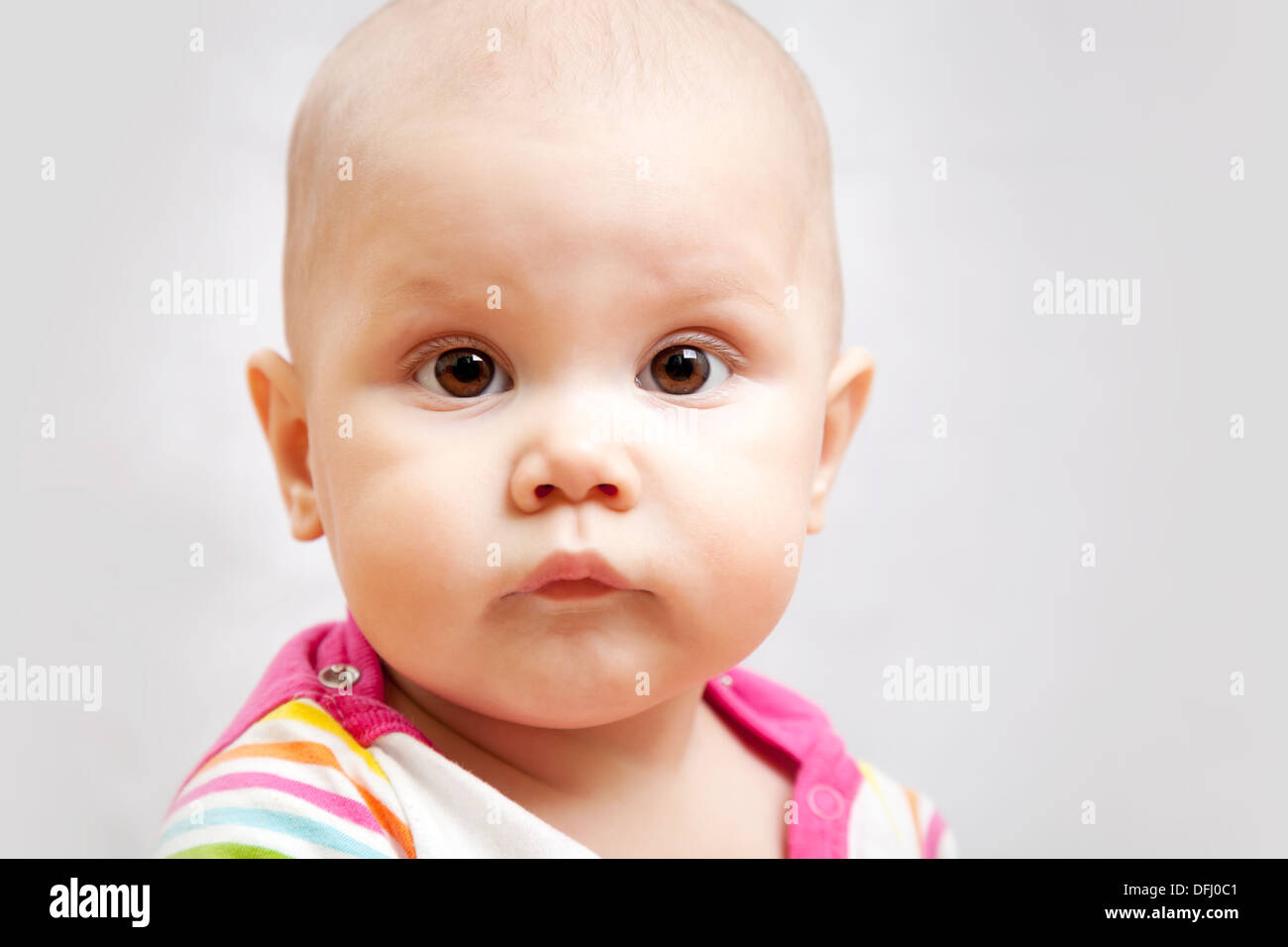 Wenig Ruhe braune Augen kaukasischen Baby Closeup Studioportrait auf grauem Hintergrund Stockfoto