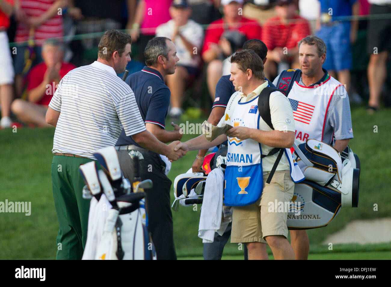 3. Oktober 2013: Internationale Teamplayer Marc Leishman schüttelt Hände mit seinem Caddie Matthew Kelly als Matt Kuchar und Tiger Woods (wieder) gratulieren einander und Kuchar Caddie Lance Bennett beim Abschluss von ihrem vier-Ball-Spiel am ersten Tag von The Presidents Cup im Muirfield Village Golf Club in Dublin, Ohio Stockfoto