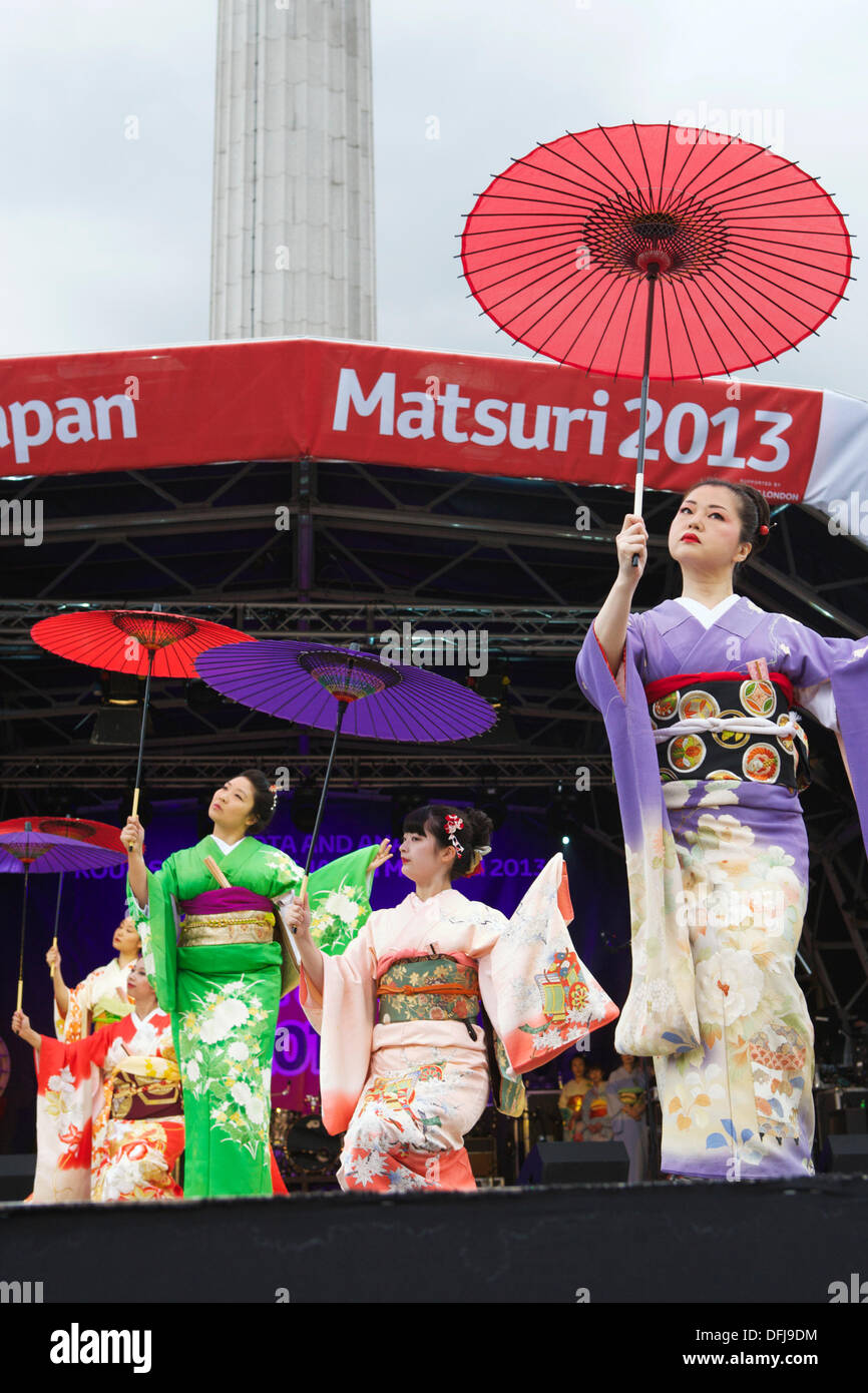 Japanische Kimono: japanische junge Geisha gekleidet in farbenfrohen Kimonos mit Sonnenschirmen, in London Japan Matsuri Tanz Stockfoto