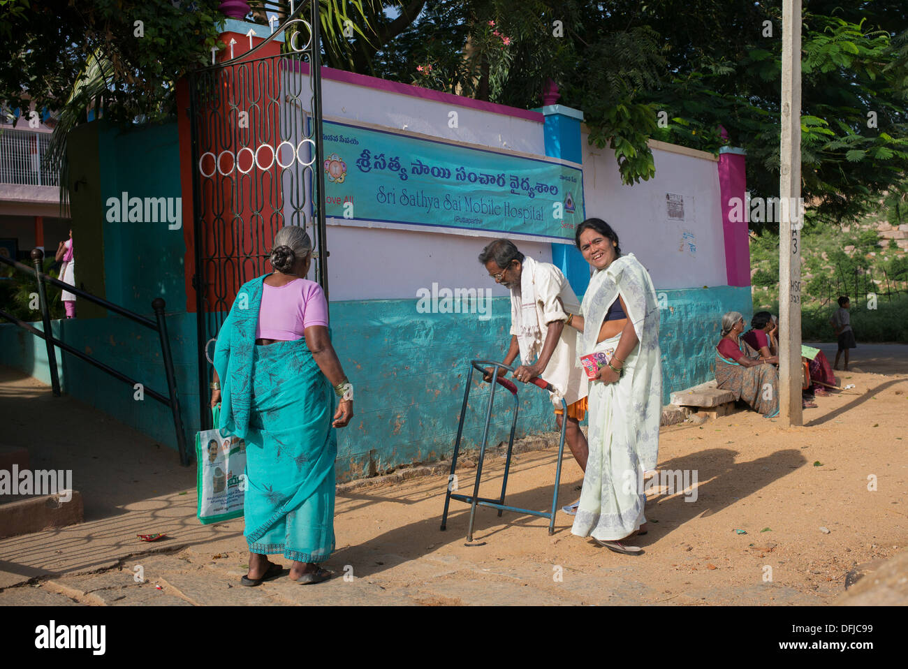 Indische Frauen und Männer, die zu Fuß in das Sri Sathya Sai Baba mobile aufsuchende Krankenhaus an einer Dorfschule. Andhra Pradesh, Indien Stockfoto