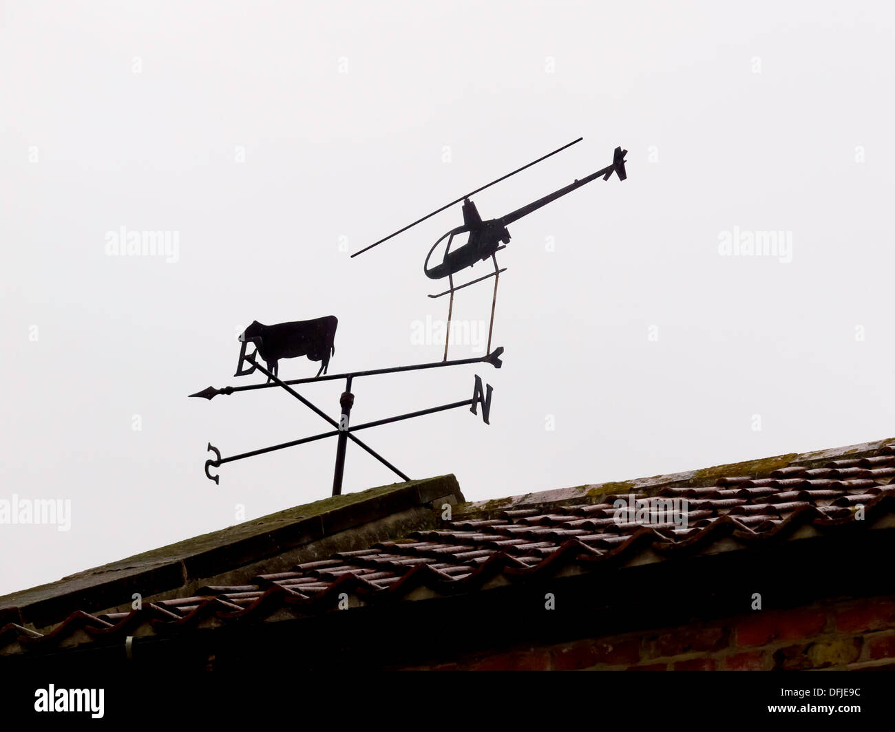 Eine ungewöhnliche Bauernhof Wetterfahne mit einer Kuh und einem Hubschrauber zeigt nach Süden Stockfoto