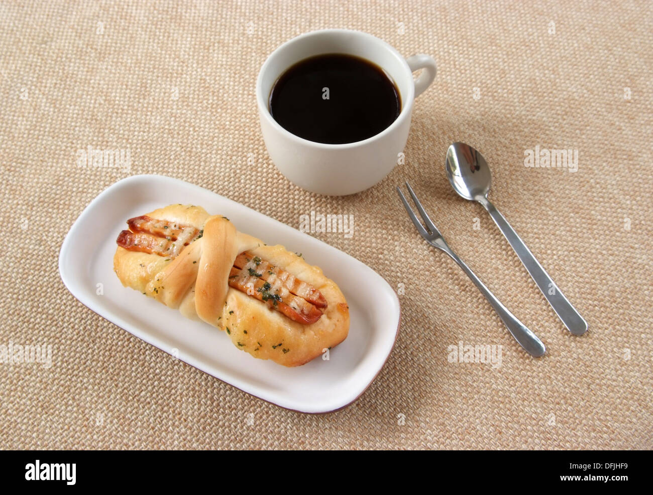 Schmackhafte Wurst Brot und Kaffee auf einem Stoff-Hintergrund Stockfoto