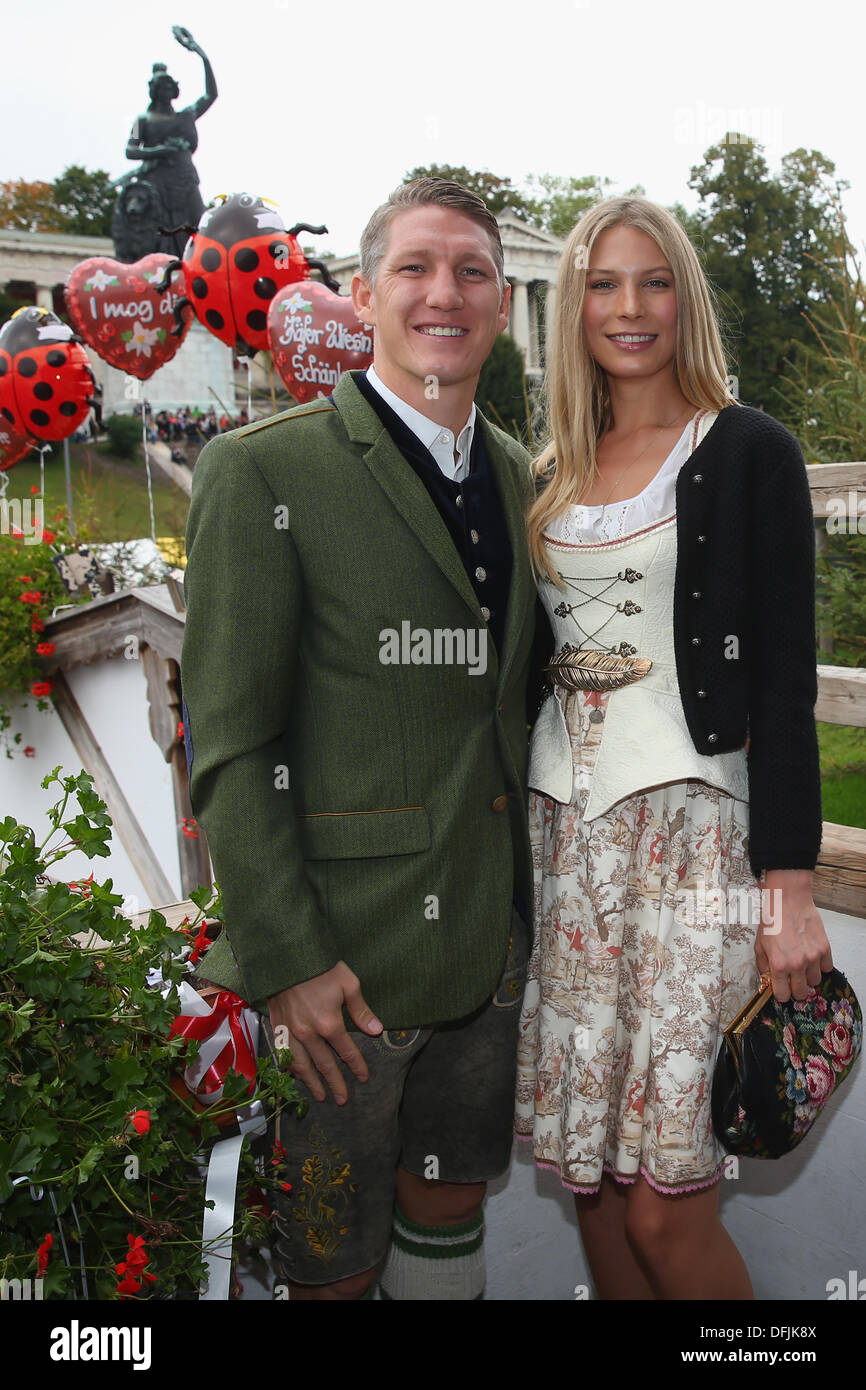 München, Deutschland - Oktober 06: Bastian Schweinsteiger von Bayern Muenchen Posen mit Sarah Brandner vor dem Ensemble der Bavaria-Statue, Sandgusstechnik eine monumentale Bronze Statue aus dem 19. Jahrhundert und die Hall Of Fame (Fresko) während dem Oktoberfest 2013 Bierfest am Kaefers Wiesenschaenke am 6. Oktober 2013 in München. Die Bavaria ist die weibliche Personifizierung der bayerischen Heimat und durch Verlängerung, seine Kraft und Herrlichkeit. Bildnachweis: Kolvenbach/Alamy Live-Nachrichten Stockfoto