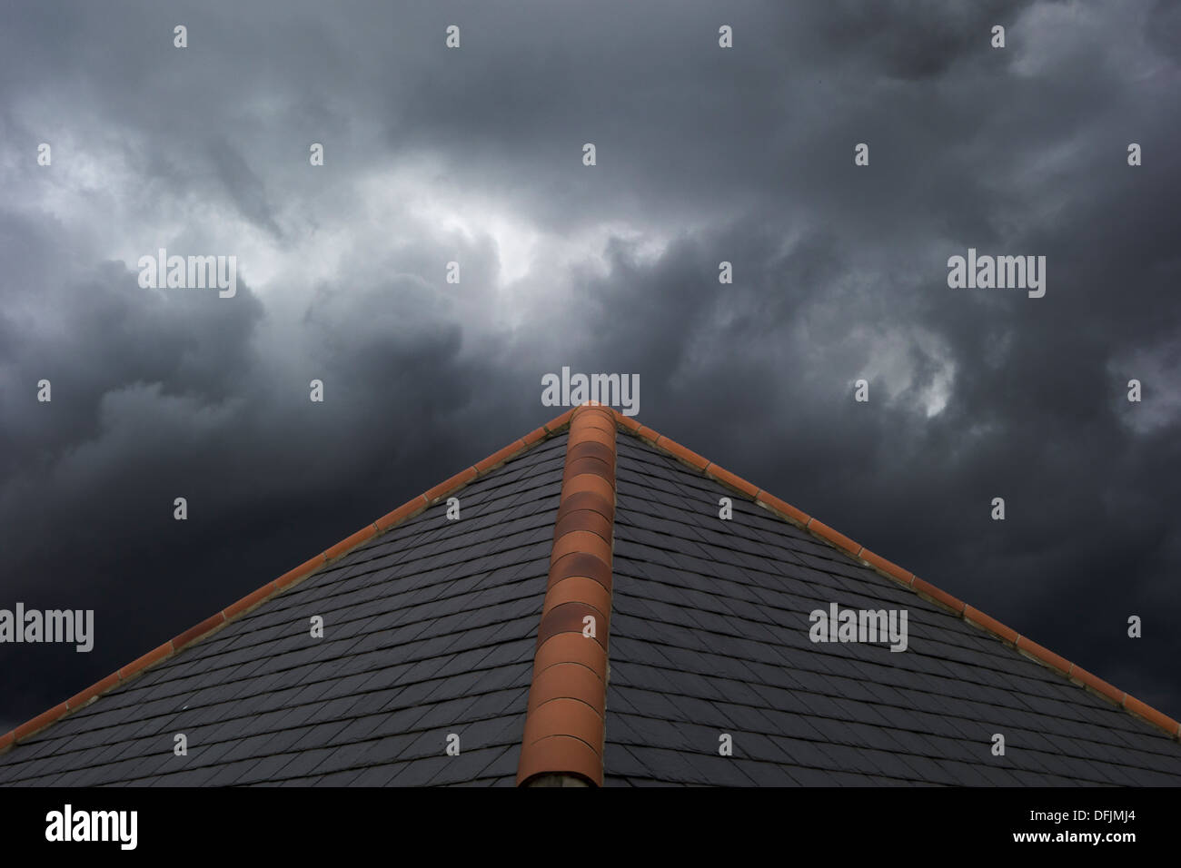 Stürmischen Wolken sammeln über ein Ziegeldach. Stockfoto