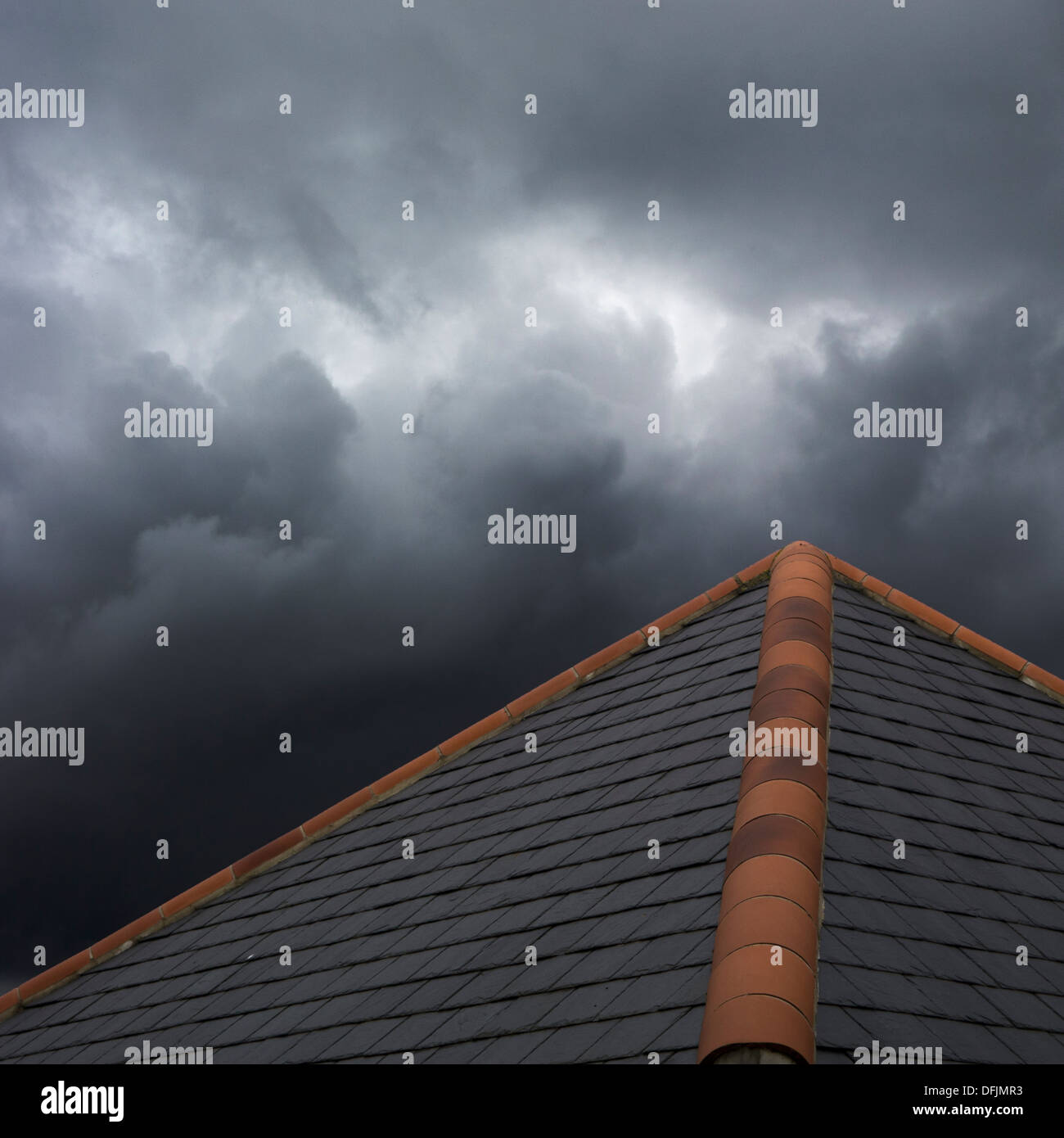 Stürmischen Wolken sammeln über ein Ziegeldach. Stockfoto