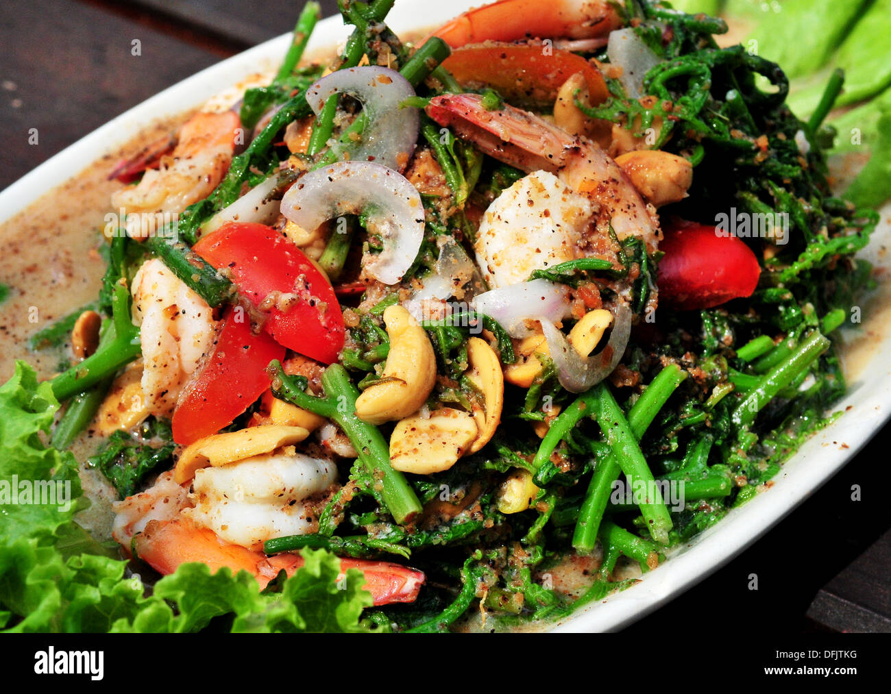 Geschmack von Thailand - thailändische Vorspeise - pikante Meeresfrüchtesalat mit lokalen Farn (Yam Pak Kood) Stockfoto