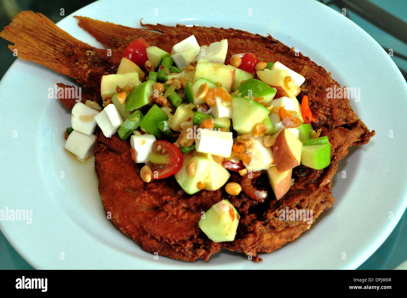 Geschmack von Thailand - Deep fried Weißfisch, garniert mit Somtam Polomai (würziger Fruchtsalat) Stockfoto