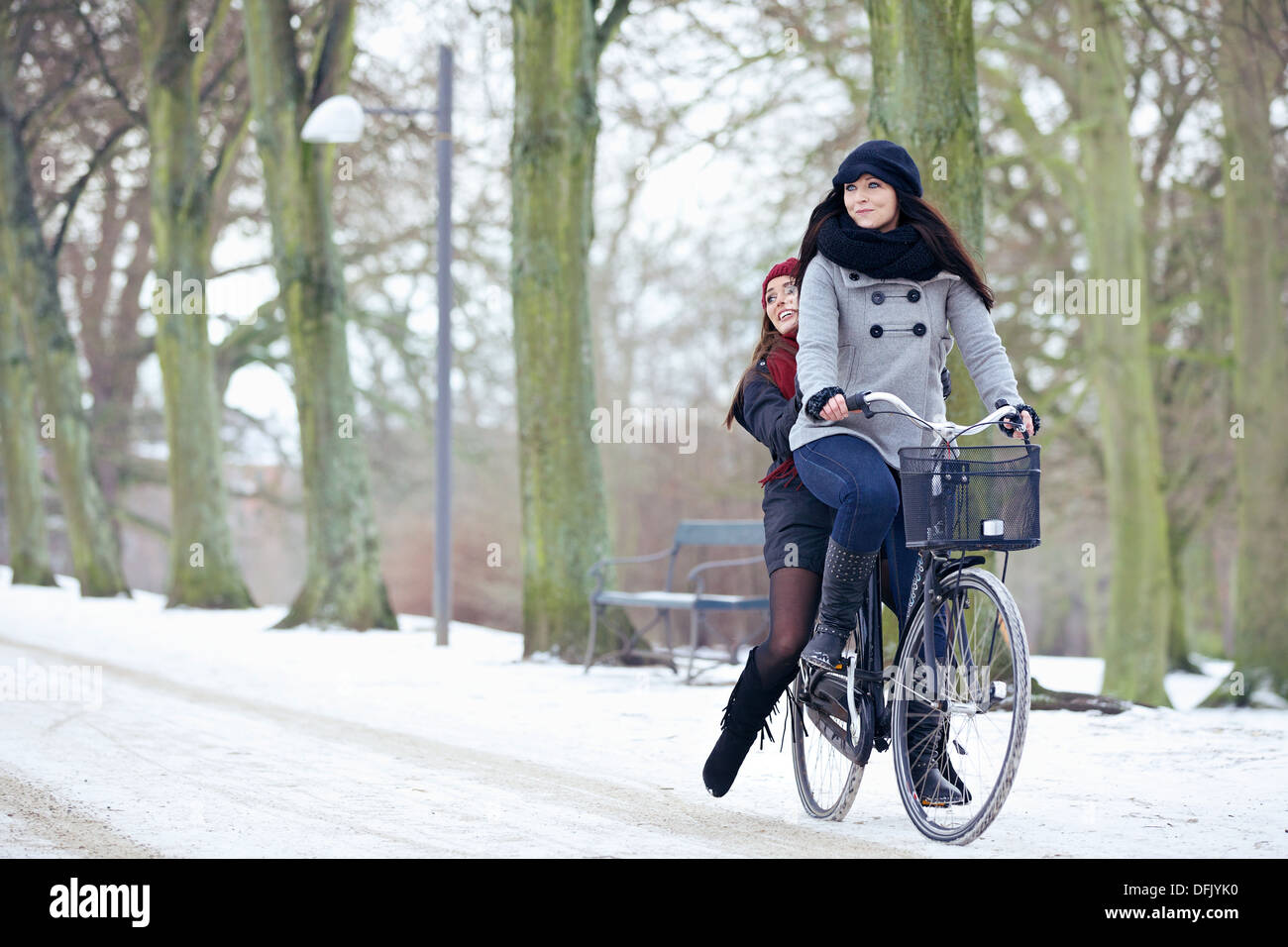 Glückliche Frauen genießen ein Fahrrad fahren im Winter park Stockfoto