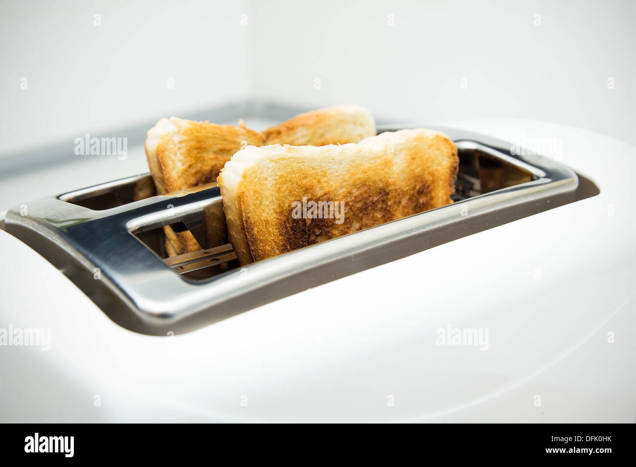 Toaster mit Brotscheiben auf weißem Hintergrund Stockfoto