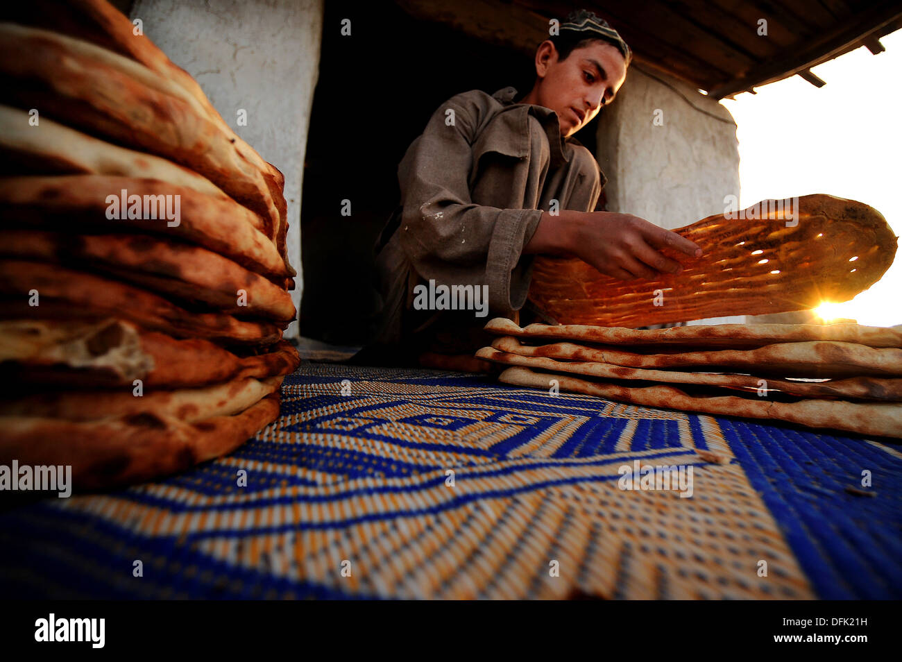 Zahir Najibullah wartet geduldig auf Kunden, die traditionelle afghanische Naan Brot bei seinem am Straßenrand Stall 7. Juni 2010 in einem kleinen Dorf in der Nähe von Kandahar, Afghanistan erwerben möchten. Stockfoto