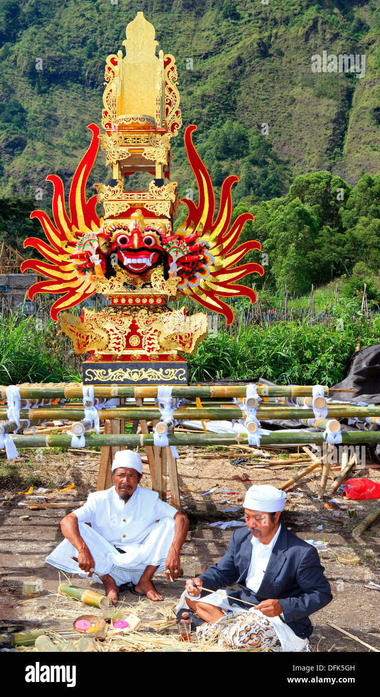 Zwei Priester eine hindu Einäscherung Zeremonie vorbereiten. Die Feuerbestattung-Turm im Hintergrund ist mit einem feierlichen Gesicht verziert. Stockfoto