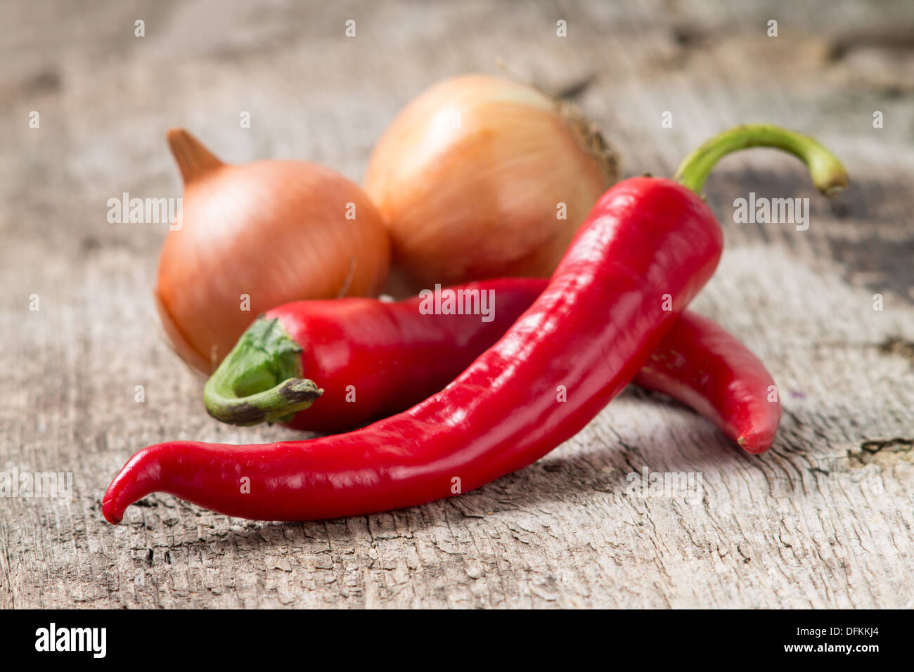 Rote Chilischote mit Zwiebel an Holz Hintergrund. Selektiven Fokus Stockfoto