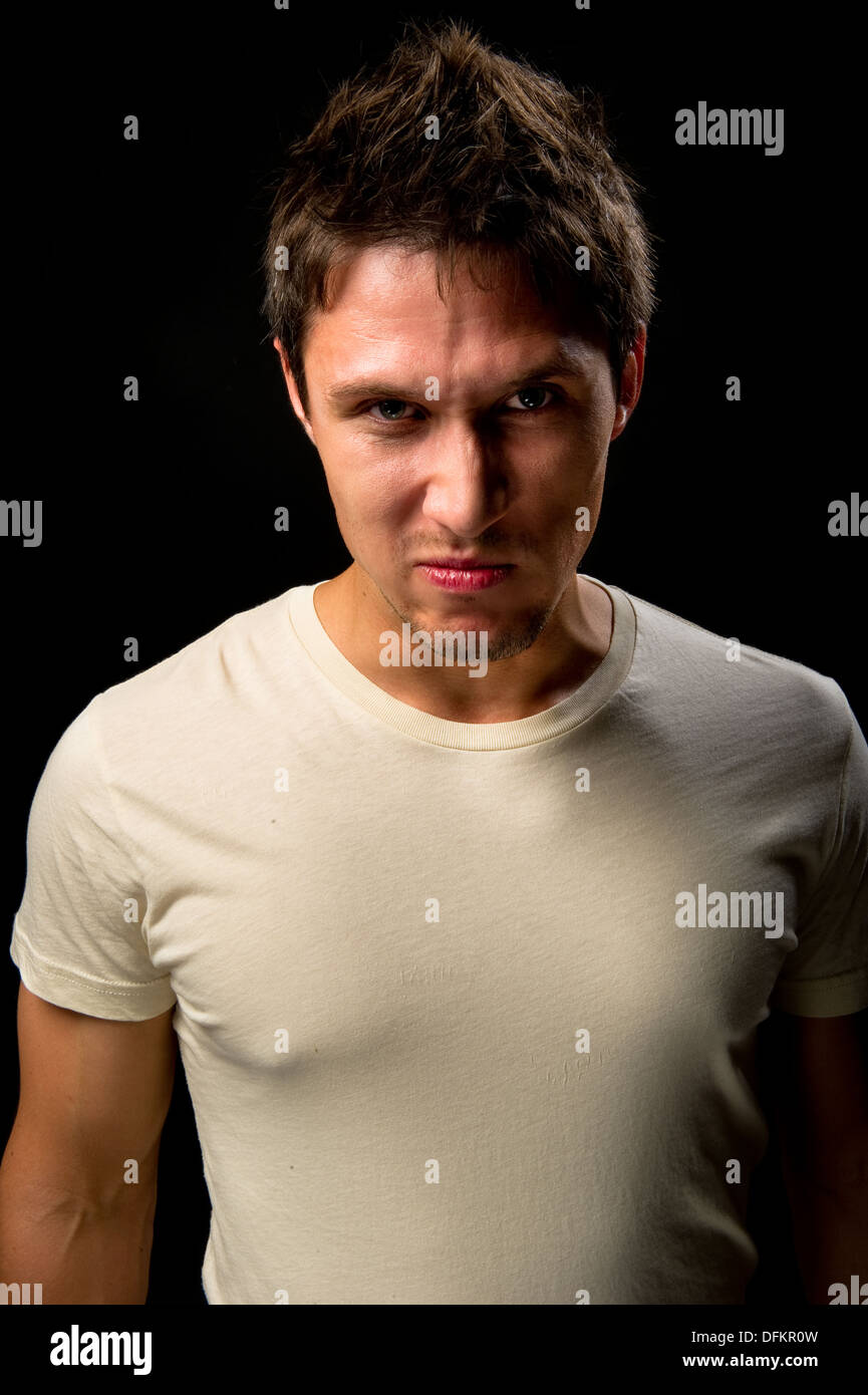 Porträt eines schön wütend auf schwarzem Hintergrund Stockfoto