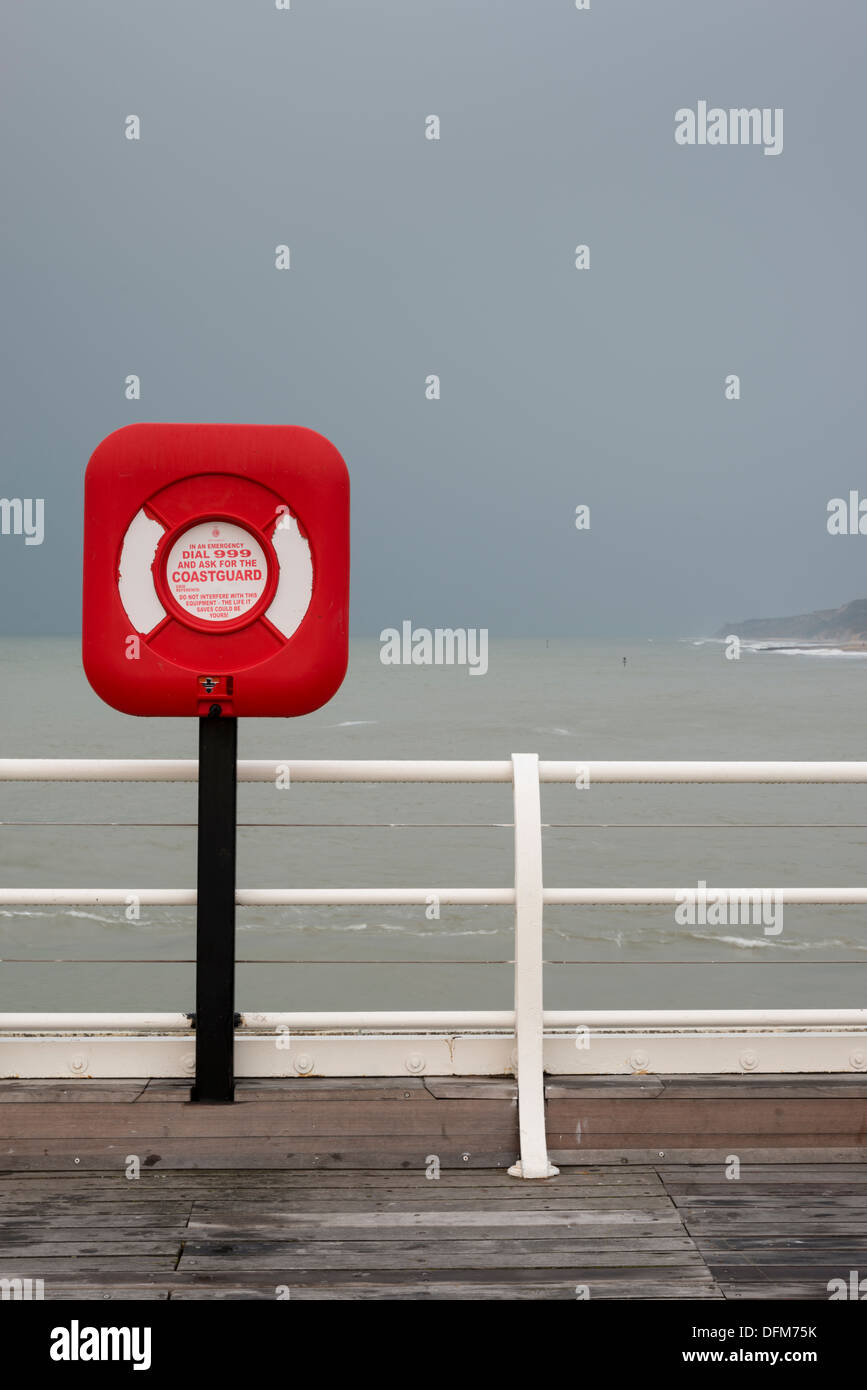 Ein Lifebouy auf Cromer Pier Norfolk UK im trüben Licht mit stark gesättigten Rottönen Stockfoto