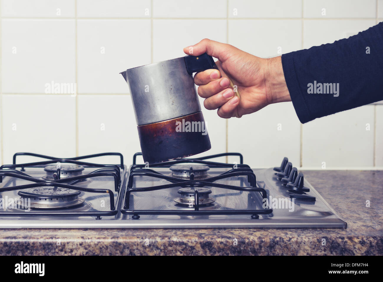 Hand des Mannes platzieren Moka Topf auf Herd Stockfoto