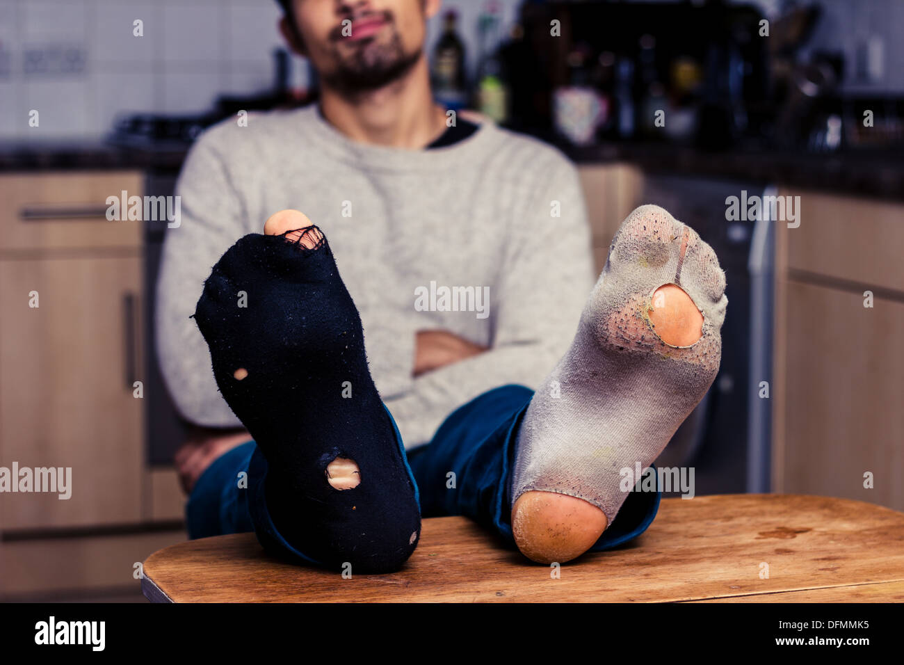 Junger Mann mit getragenen Socken am Tisch Stockfotografie - Alamy