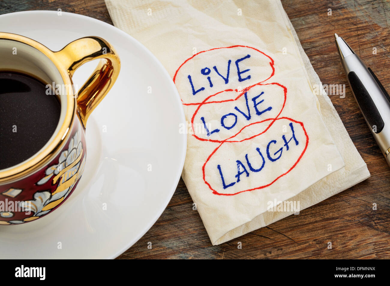 Leben Sie, lieben Sie, lachen Sie-motivierende Worte - eine Serviette Doodle mit einer Tasse Espressokaffee Stockfoto
