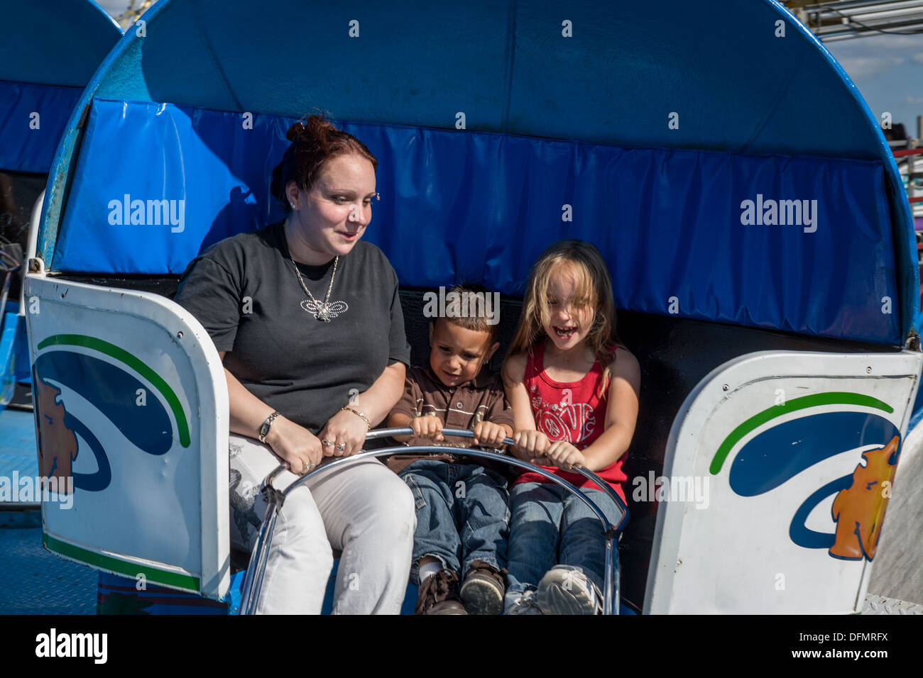 Mutter und ihre kleinen Kinder auf Tilt-a-Whirl, Great New York State Fair. Stockfoto