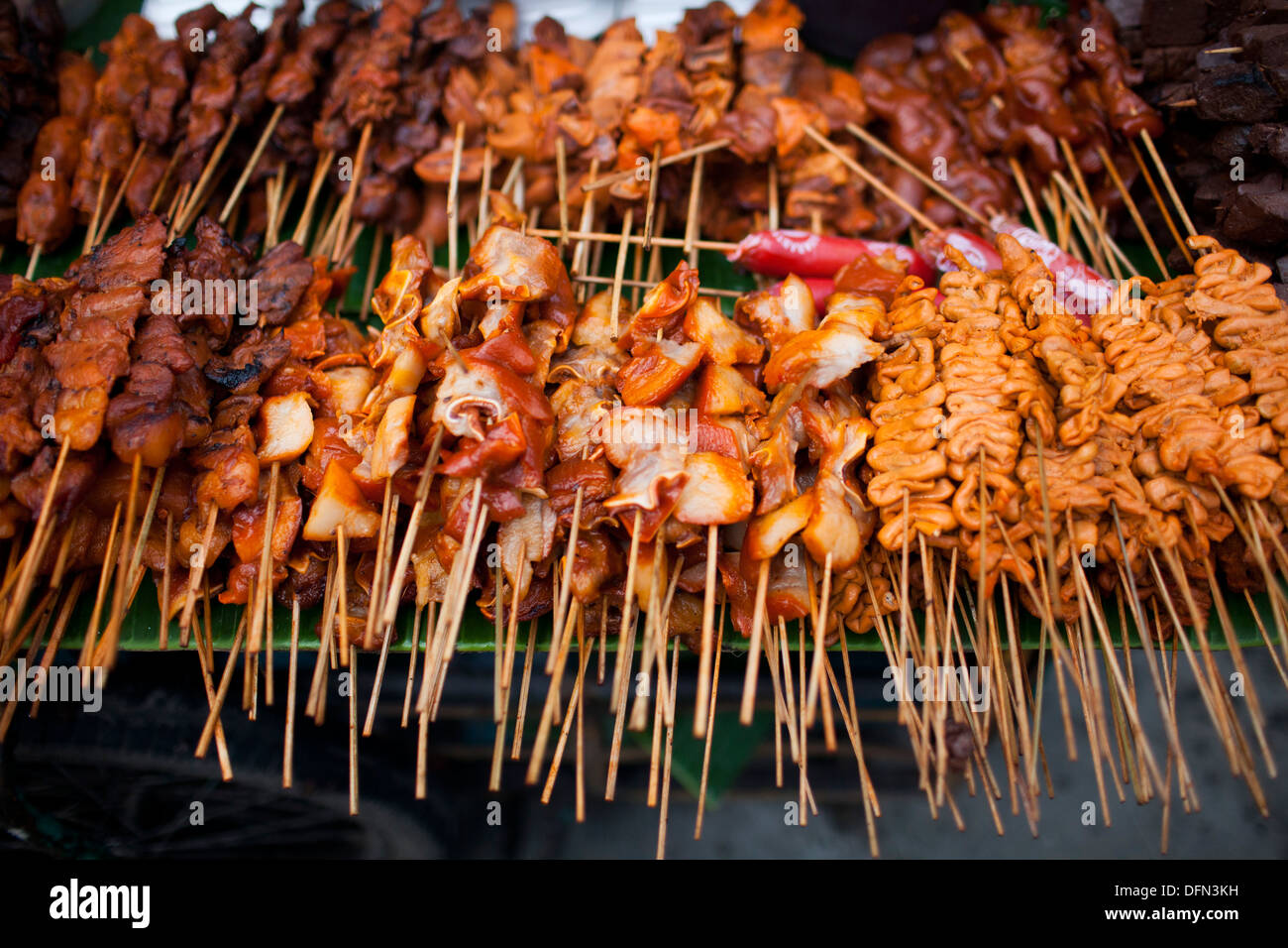 Hühnerteile aufgespießt auf Stöcke auf einem Speiselokal Lieferanten Wagen in Baclaran, Manila, Philippinen. Stockfoto