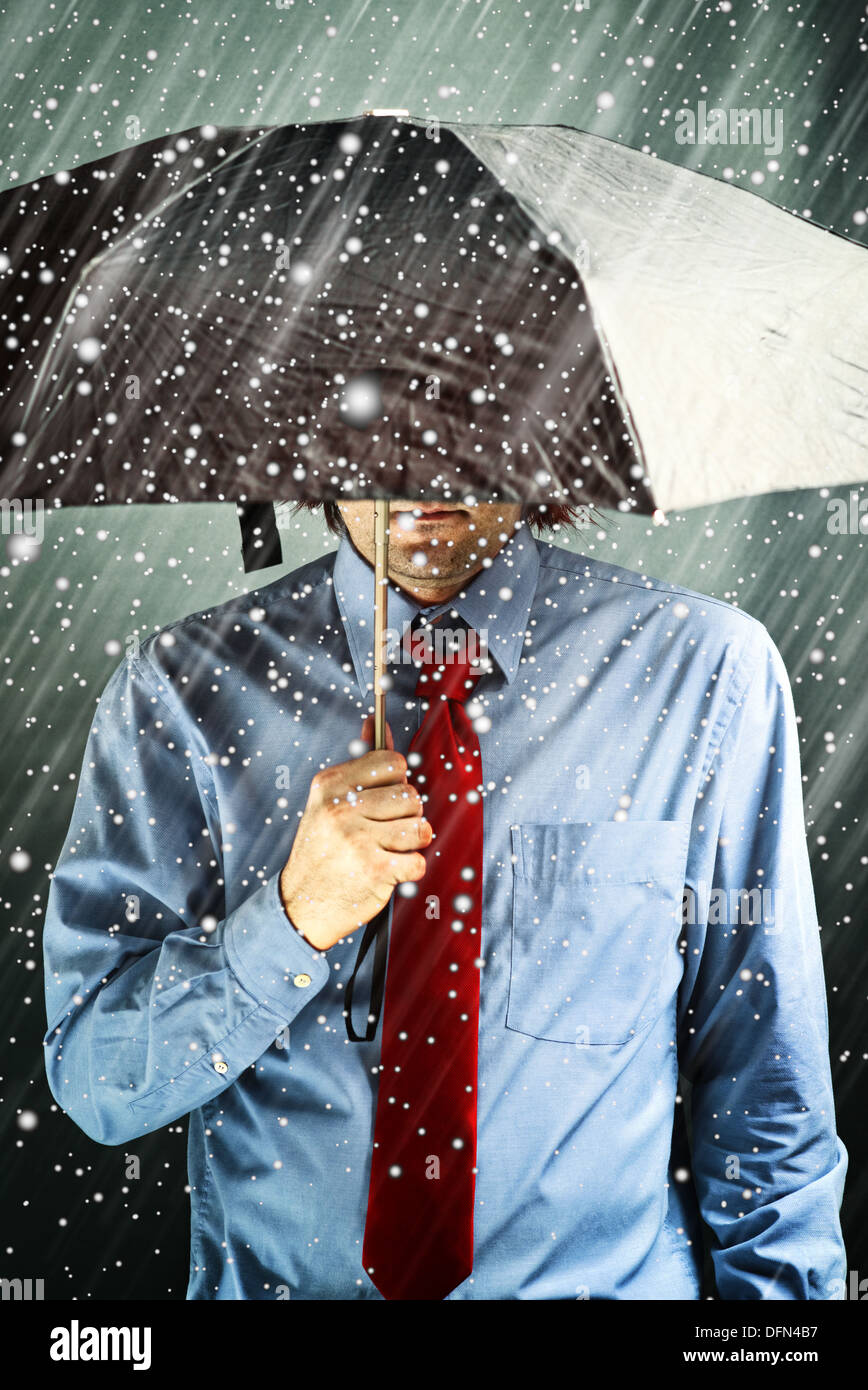 Geschäftsmann mit schwarzen Regenschirm schützt sich vor dem Sturm. Finanzielles Problem, Wirtschaftskrise, harte Zeiten-Konzept. Stockfoto