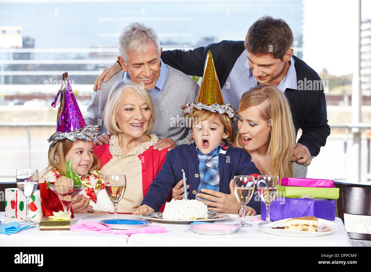 Fröhlicher Junge Ausblasen einer Kerze auf seiner Geburtstagsparty Stockfoto