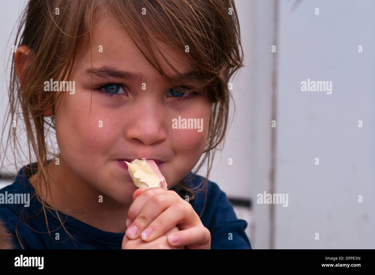 Kleine Mädchen essen eine zähe süße Stockfoto