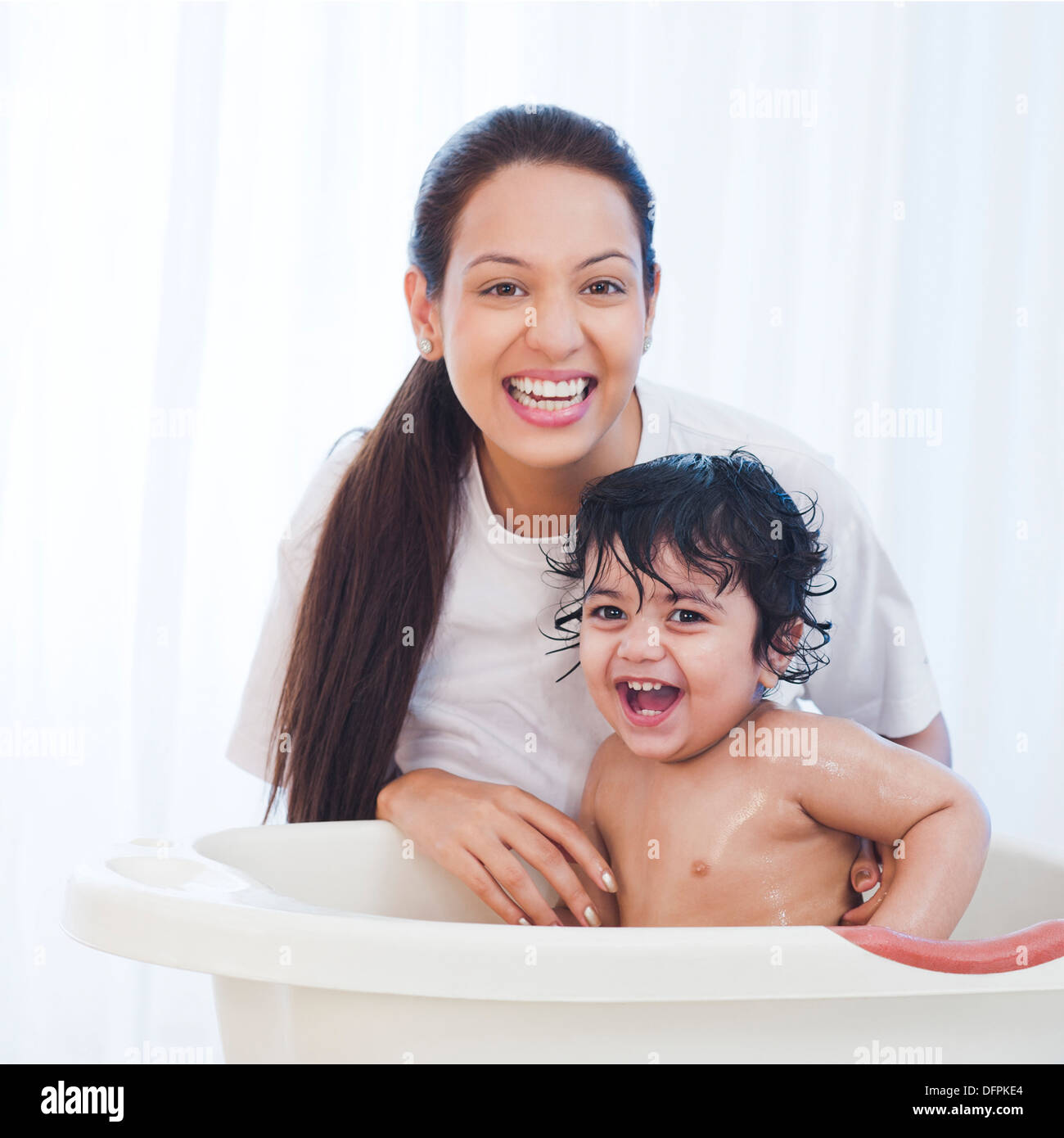 Nahaufnahme einer Frau geben Bad zu ihrem Sohn und lächelnd Stockfoto