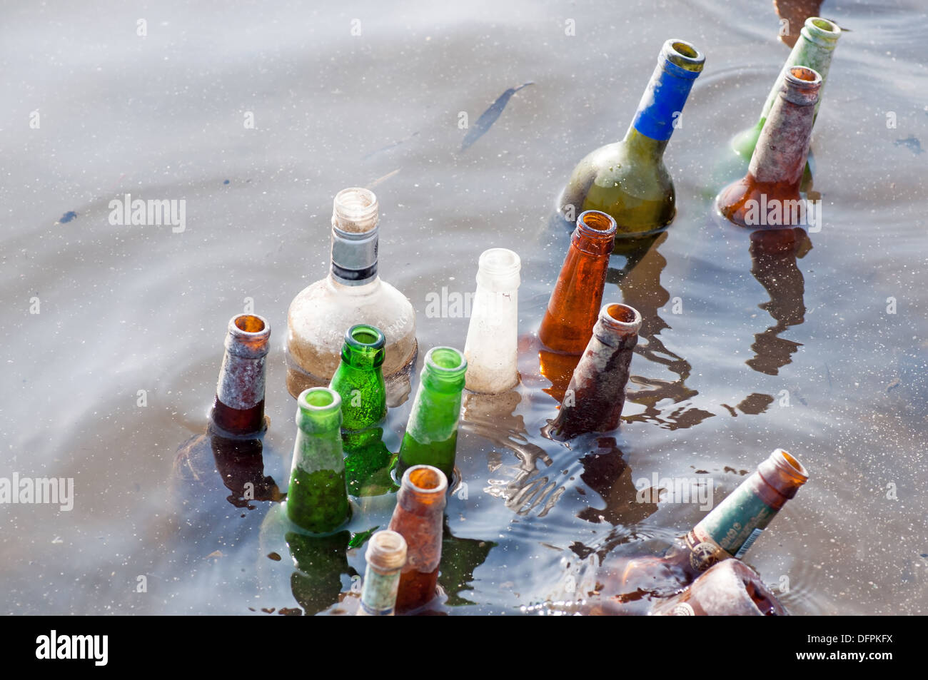 Schlechte Ökologie - alte Flaschen Schwimmer im Fluss Stockfoto