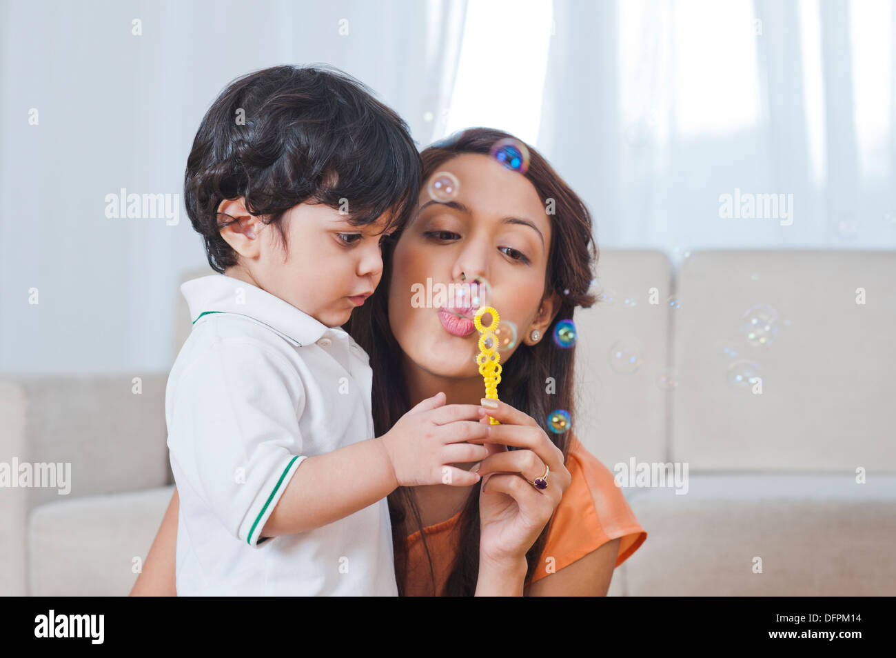 Frau und ihr Sohn Seifenblasen mit einer Blase Stockfoto