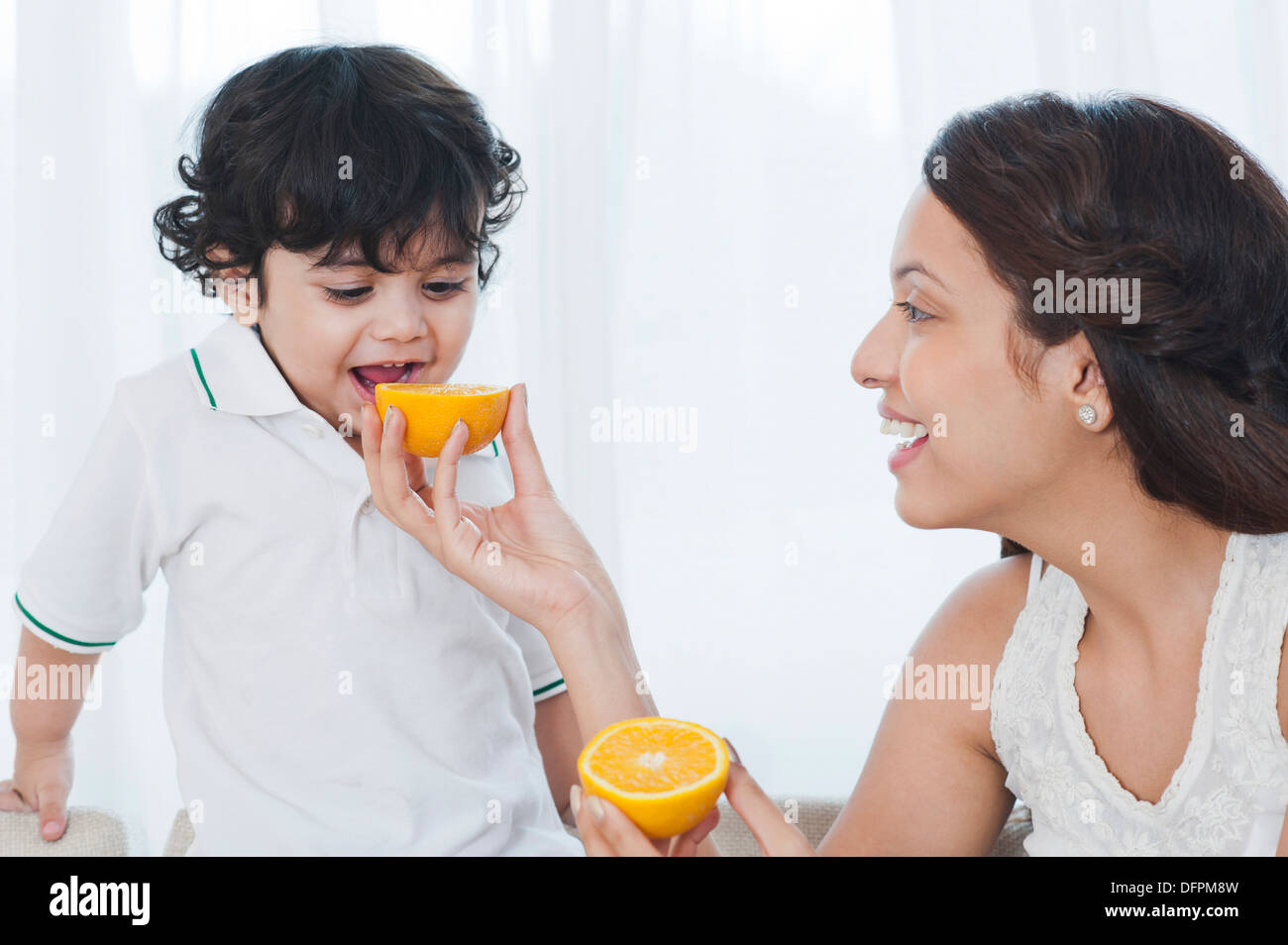Frau, die Verfütterung von Orange an ihren Sohn Stockfoto