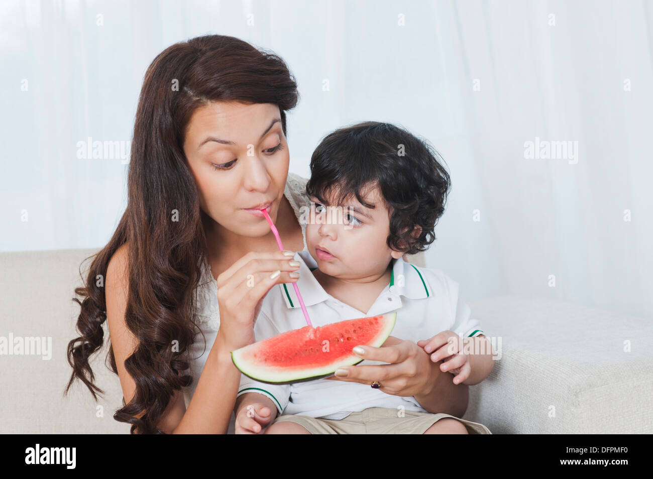 Frau saugt Saft aus Wassermelone Stockfoto