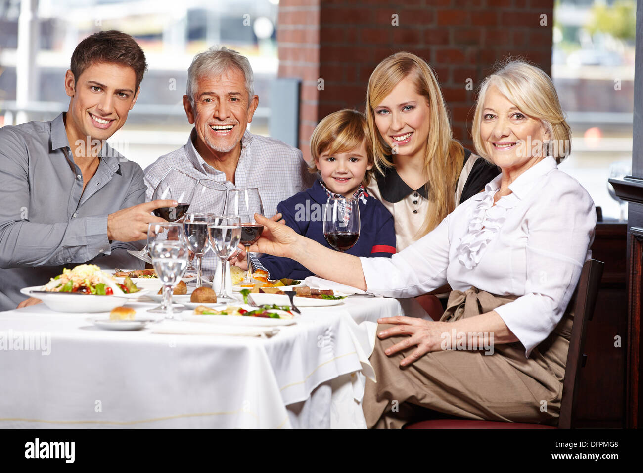 Glückliche Familie mit Kind klirrende Gläser in einem restaurant Stockfoto