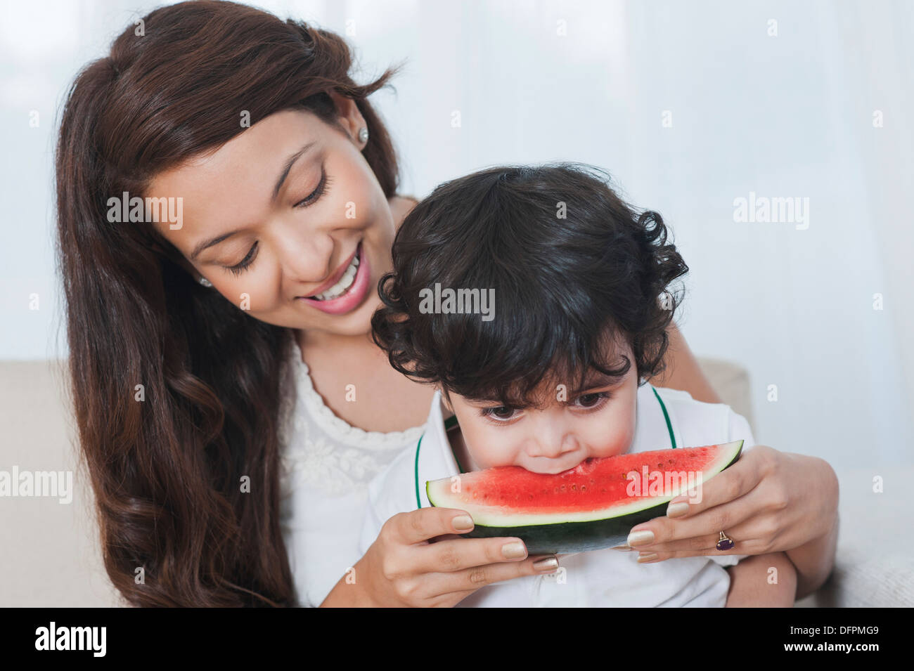Nahaufnahme einer Frau Fütterung Wassermelone zu ihrem Sohn Stockfoto