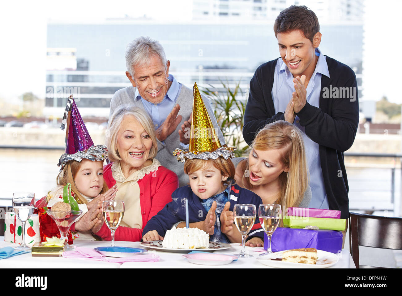 Alles Gute zum Geburtstagskind Ausblasen einer Kerze mit seiner Familie Stockfoto