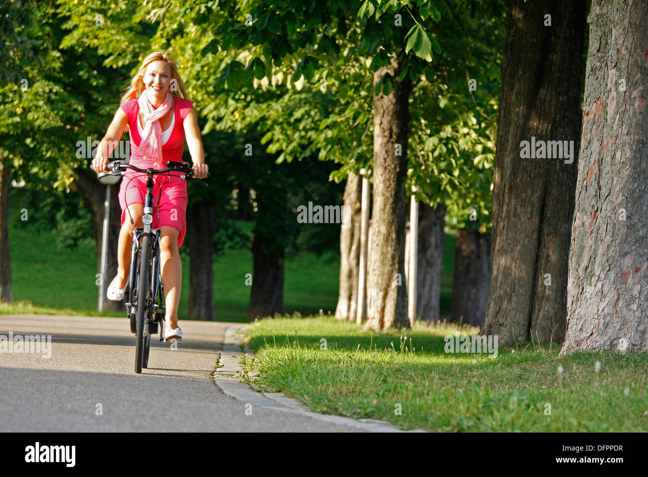 Deutschland, Stuttgart, Rosensteinpark, e-Biken. Frau, Radfahren im Park Stockfoto